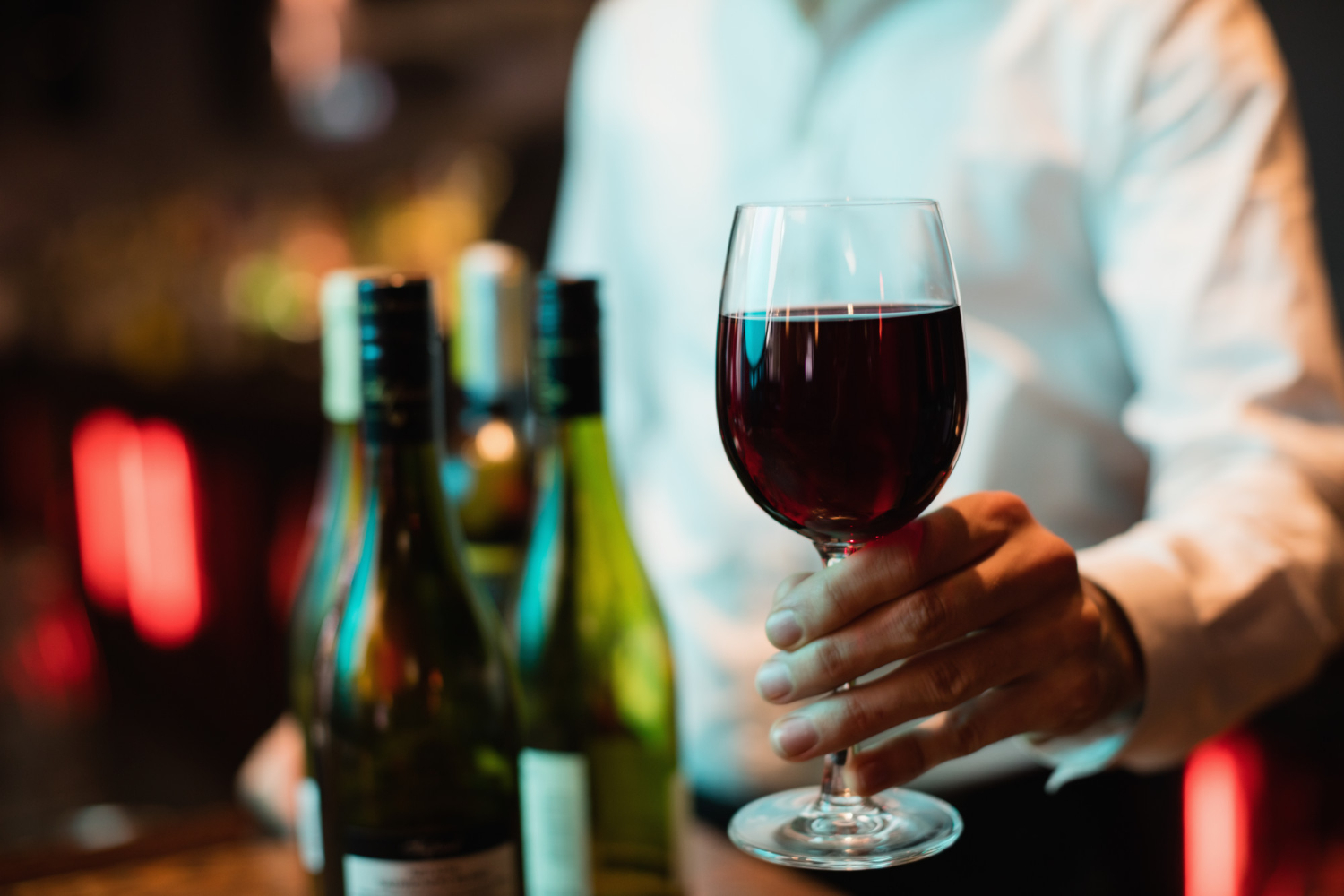 wino w kieliszku w rękach kelnera